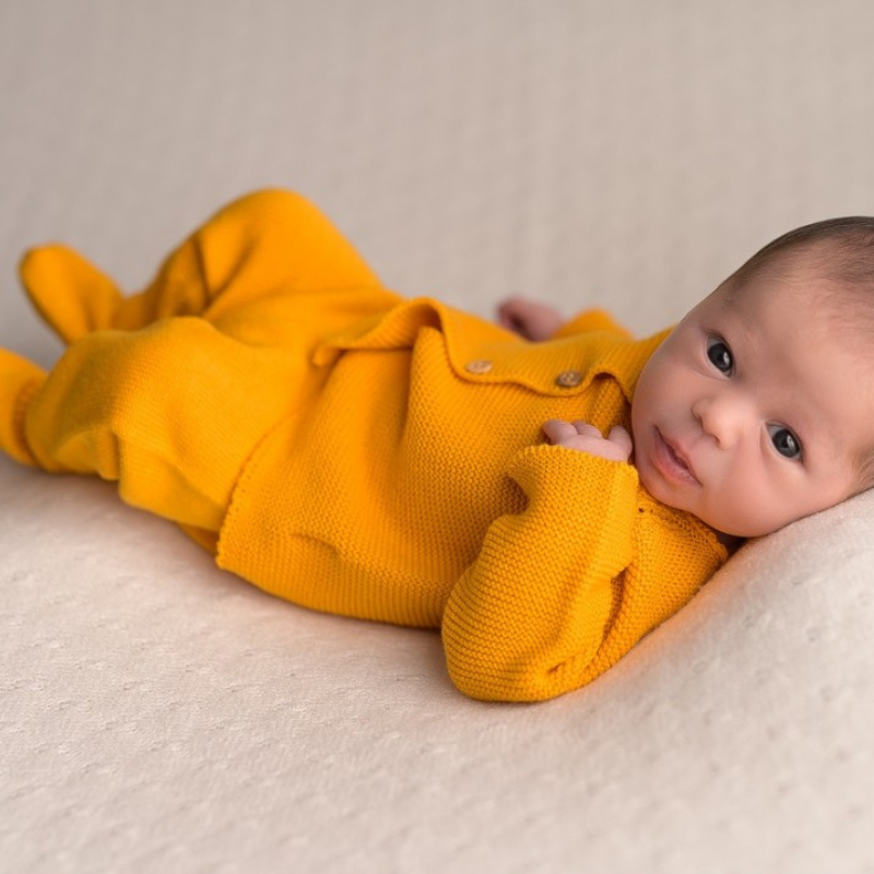 Bebé recién nacido en ropa naranja. un niño nacido en otoño. recién nacido  en el hospital